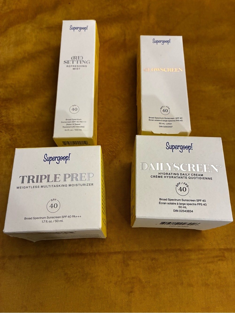 Supergoop! skincare set in white and yellow packaging
